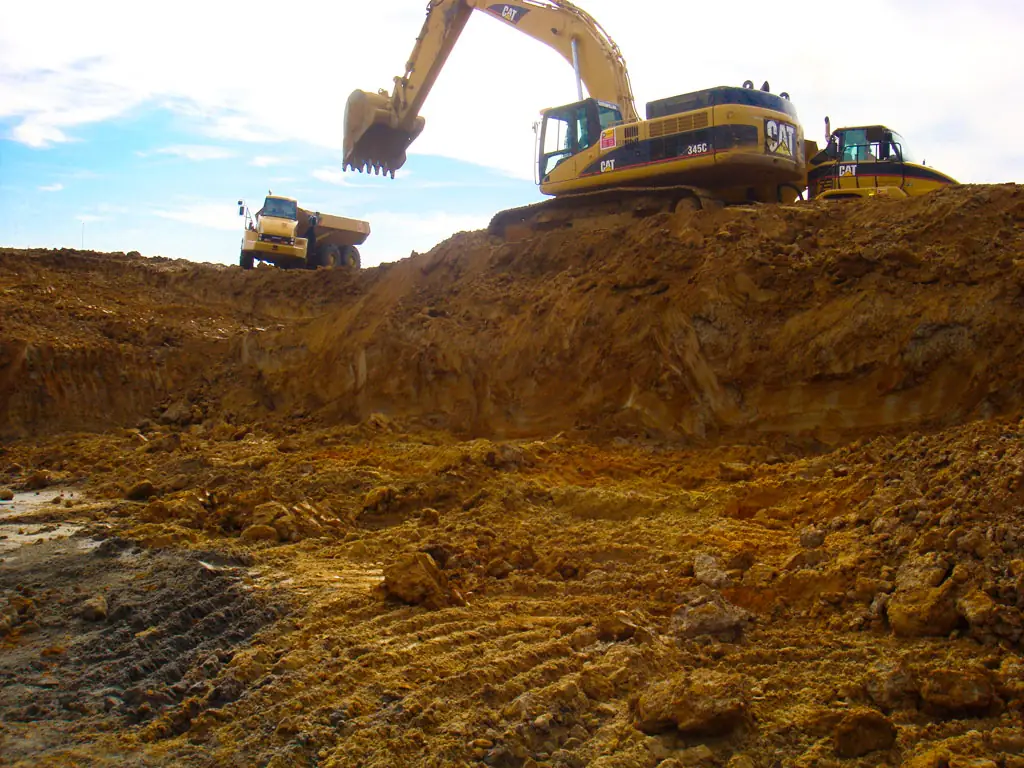 Excavators shaping a foundation site, used as representative stock photography